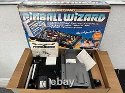 La traduction en français de ce titre est : <br/> 'Flipper vintage Boxed Grandstand Pinball Wizard des années 1980 entièrement fonctionnel.'